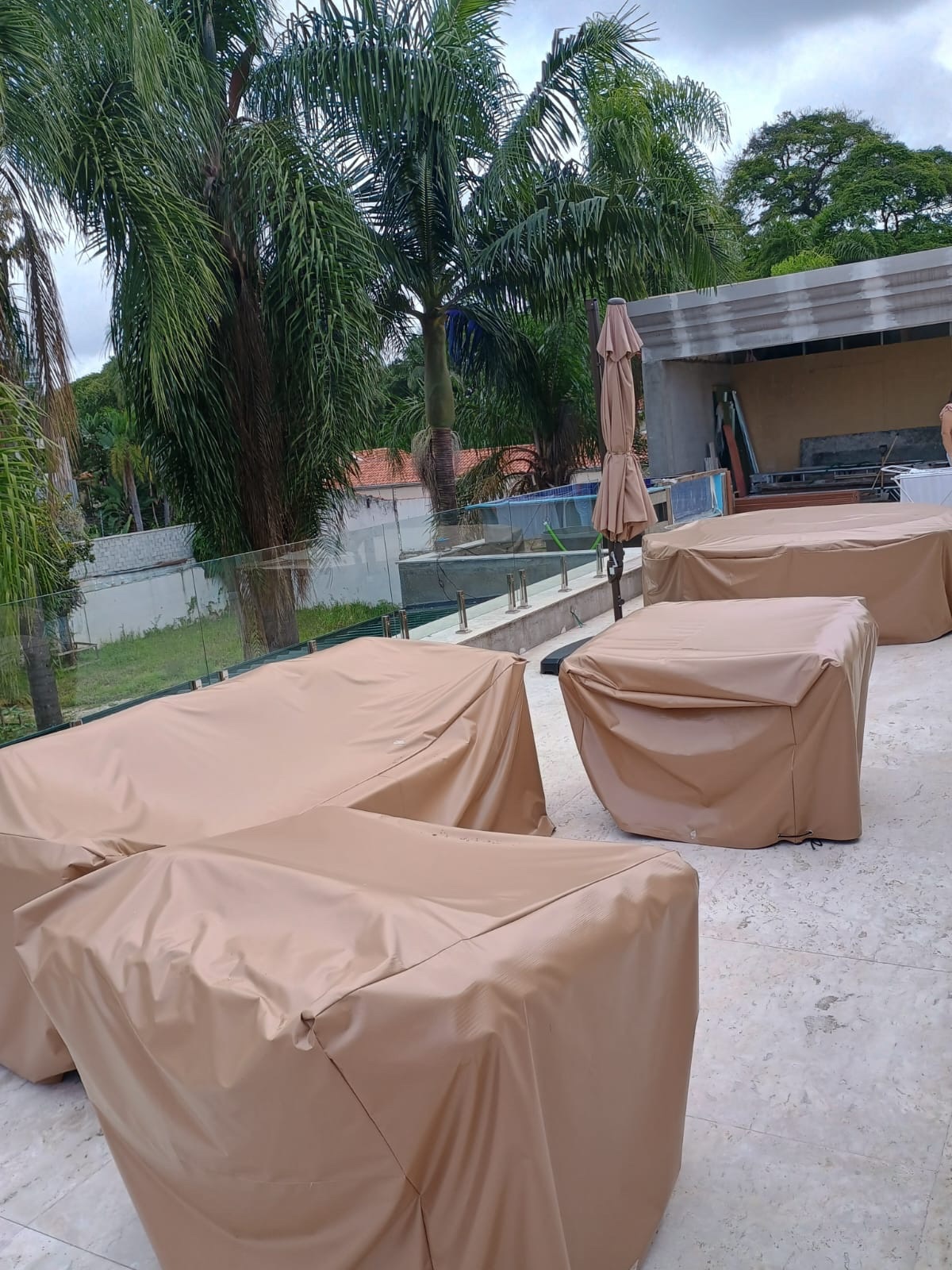 Sofás de área externa com capas em tom areia